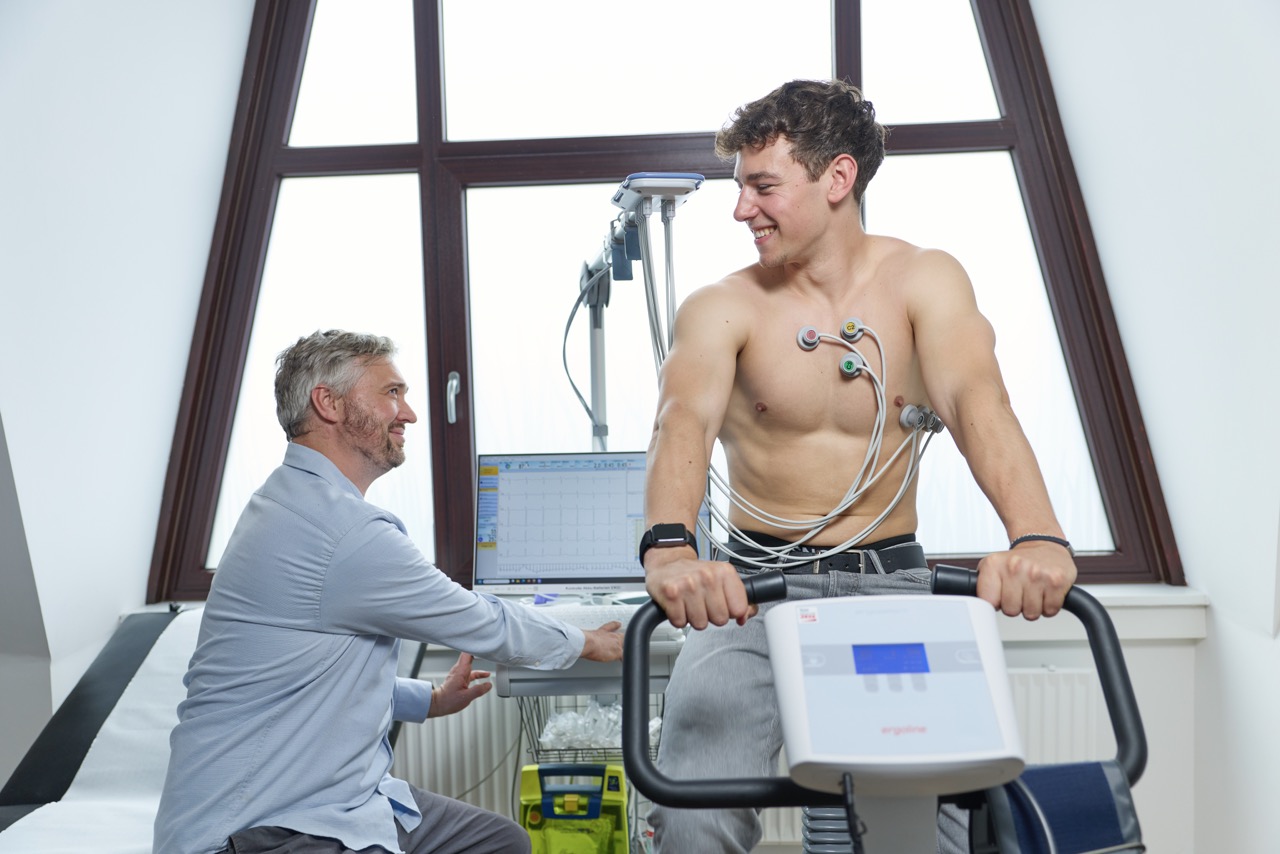Arzt begleitet jungen Mann beim Belastungs-EKG